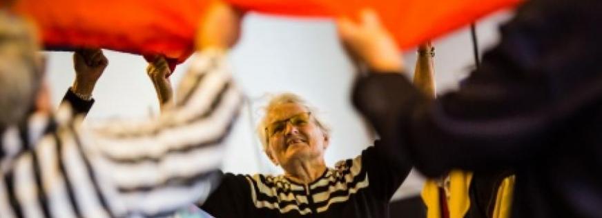 Ældre kvinde laver fysisk aktivitet med andre plejecenterbeboere