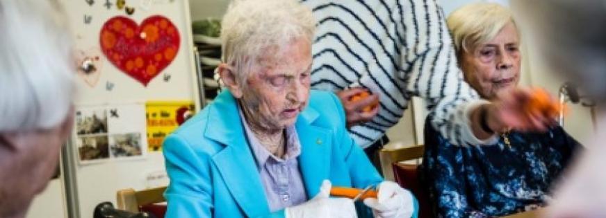Beboere på plejecenter skræller gulerødder